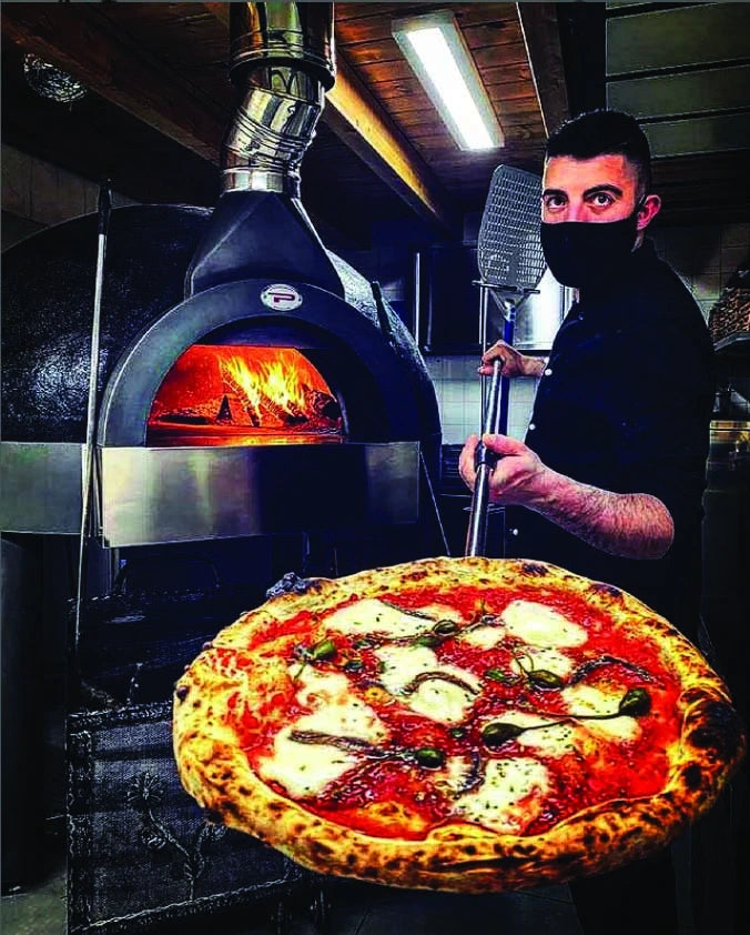 Pizzaiolo with a pizza baked in a Pavesi Forni JOY 140 oven