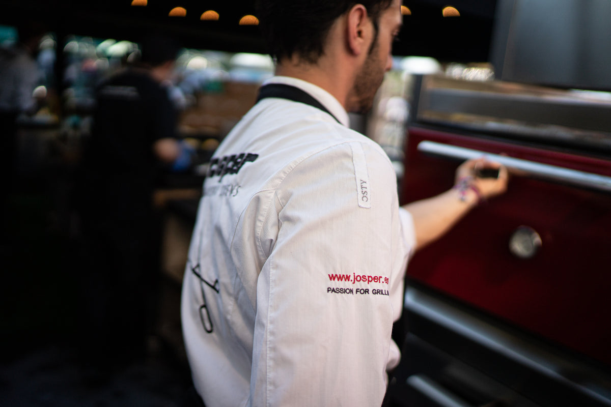 Chef working at a Josper charcoal oven in a professional kitchen