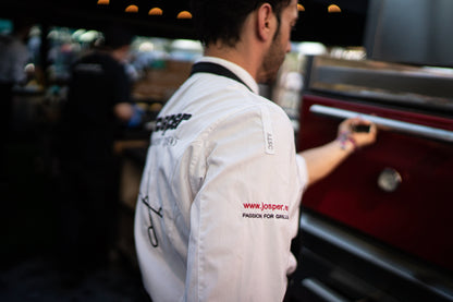 Chef working at a Josper charcoal oven in a professional kitchen