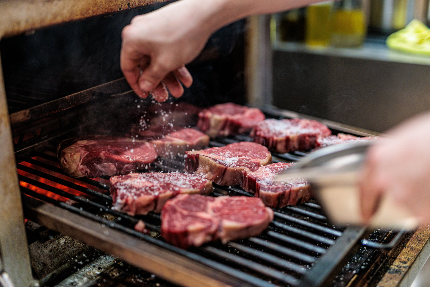 Meat searing over charcoal on an open Josper grate